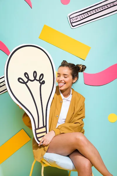 Portrait of a schoolgirl holding a large light bulb